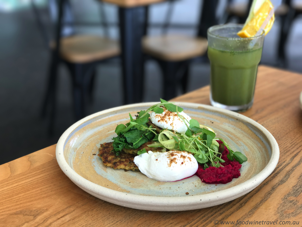 Zucchini fritters with beetroot hummus, poached eggs, dukkah, sautéed kale and cucumber ribbons