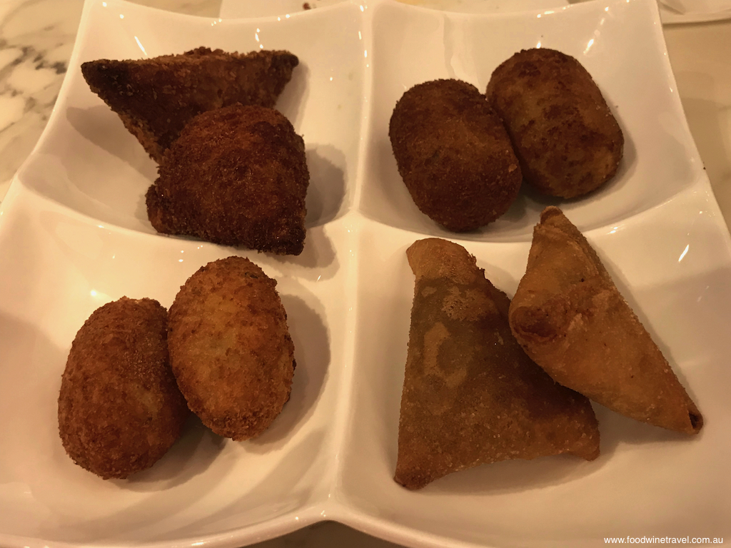 Sab 8 snack platter with fried pork and shrimp cakes, fried bacalhau (codfish) balls, and spicy sardine samosas.