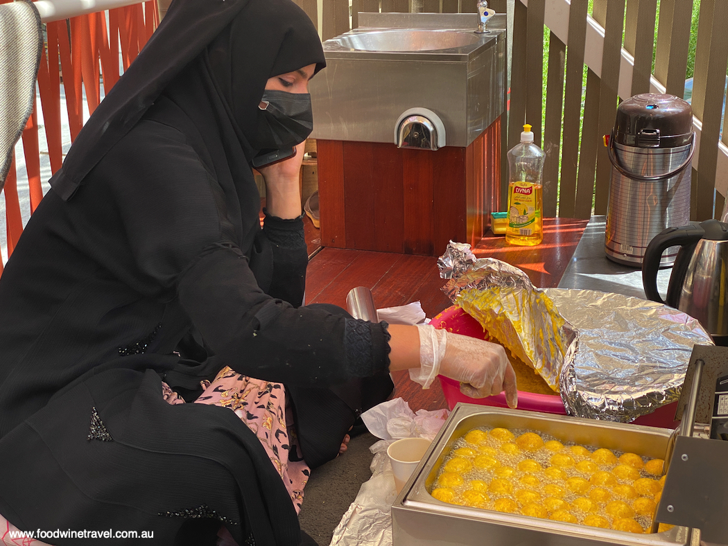In the Sameem pavilion, a woman makes luqaimat, dumplings deep-fried and dipped in honey.