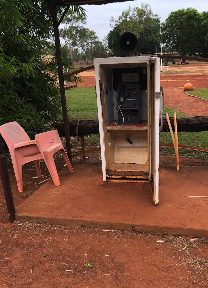 Keeping in touch with home from a pay phone at Drysdale River Station.