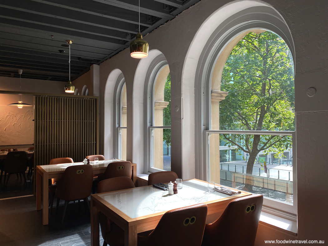 The arched windows in Dixson & Sons look out over the leafy treetops of Castlereagh Street.