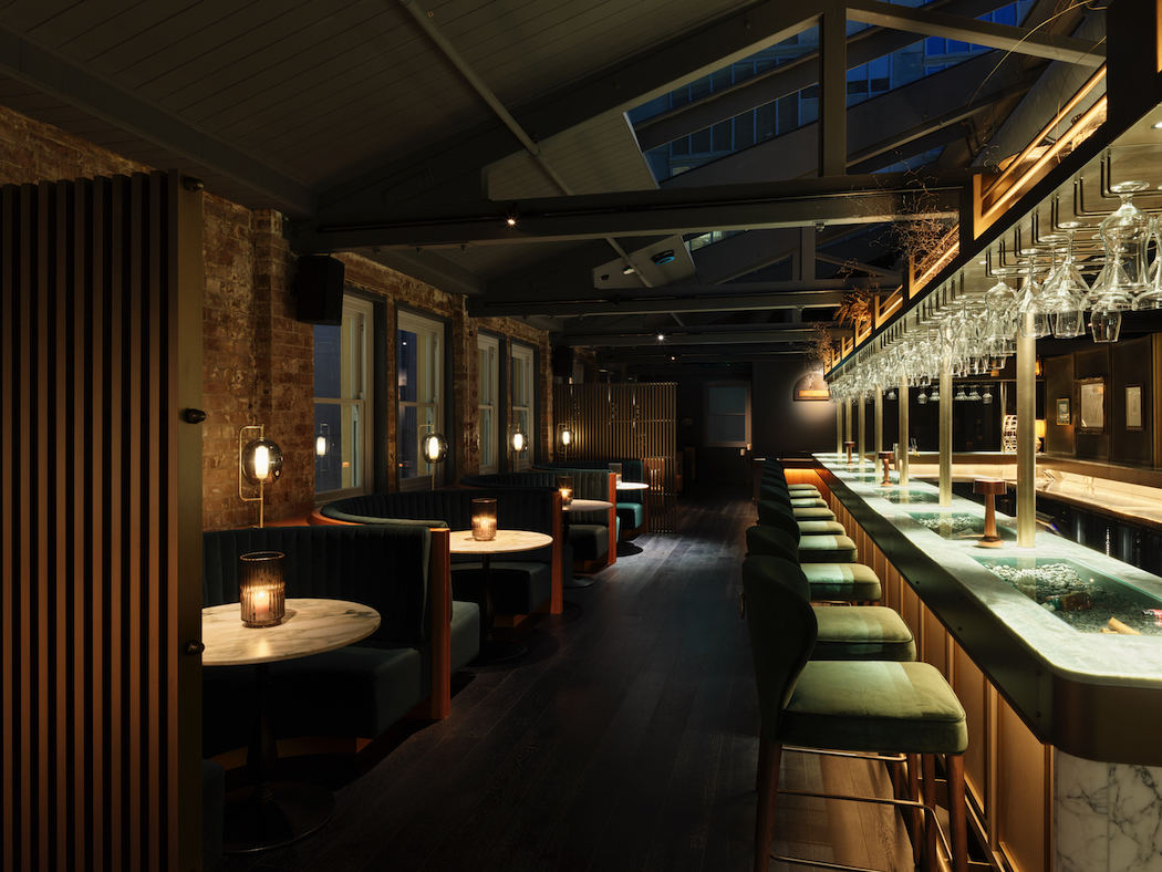 Green velvet banquettes near the historic arched windows, and the long green marble bar in Spice Trader.