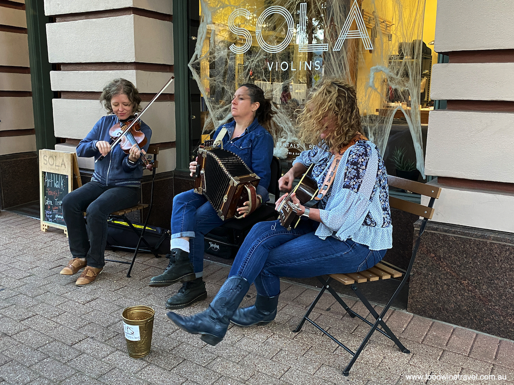 Anya Burgess, left, and fellow members of Bonsoir Catin performing outside of Sola Violins.