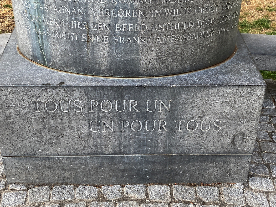 The inscription “Un pour tous, tous pour un" on D'Artagnan's statue in Maastricht.