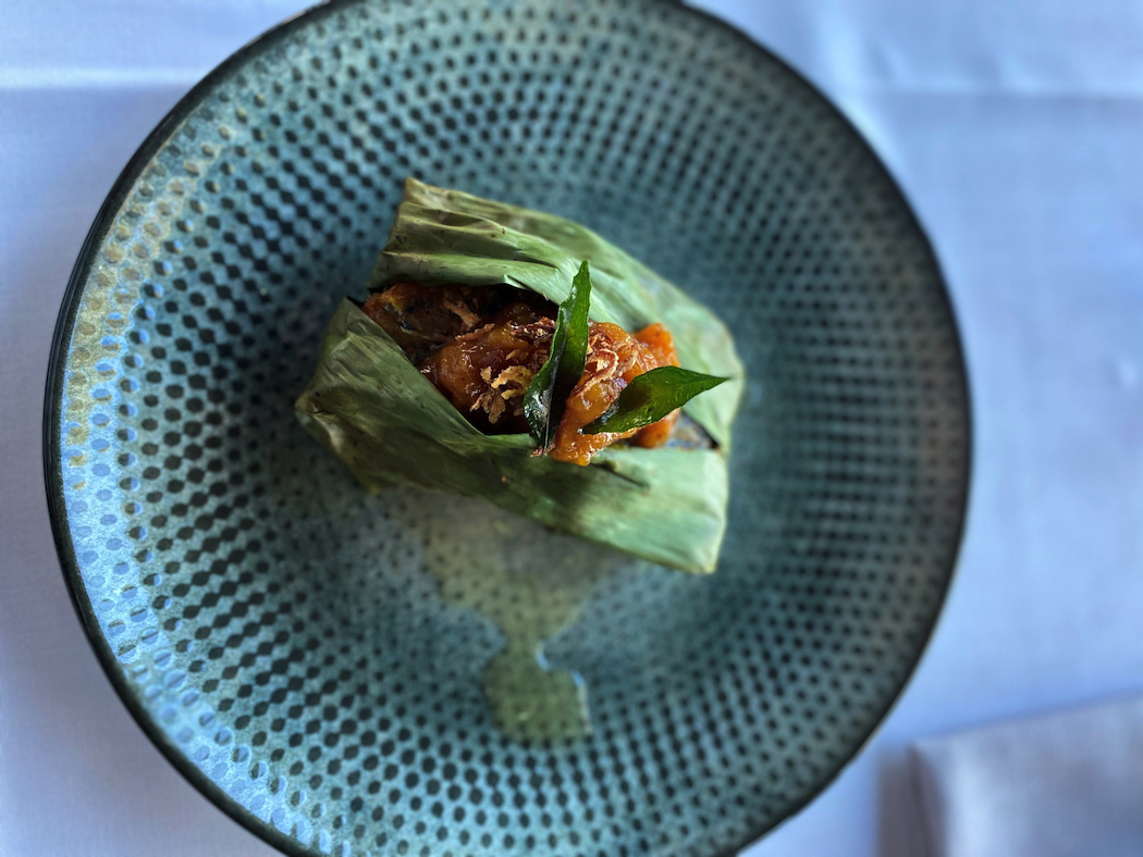 A fusion of flavours and techniques: Barramundi, wrapped and baked in banana leaf, with mango chutney.
